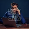 Изображение мужчина сидящий в наушниках за столом с ноутбуком